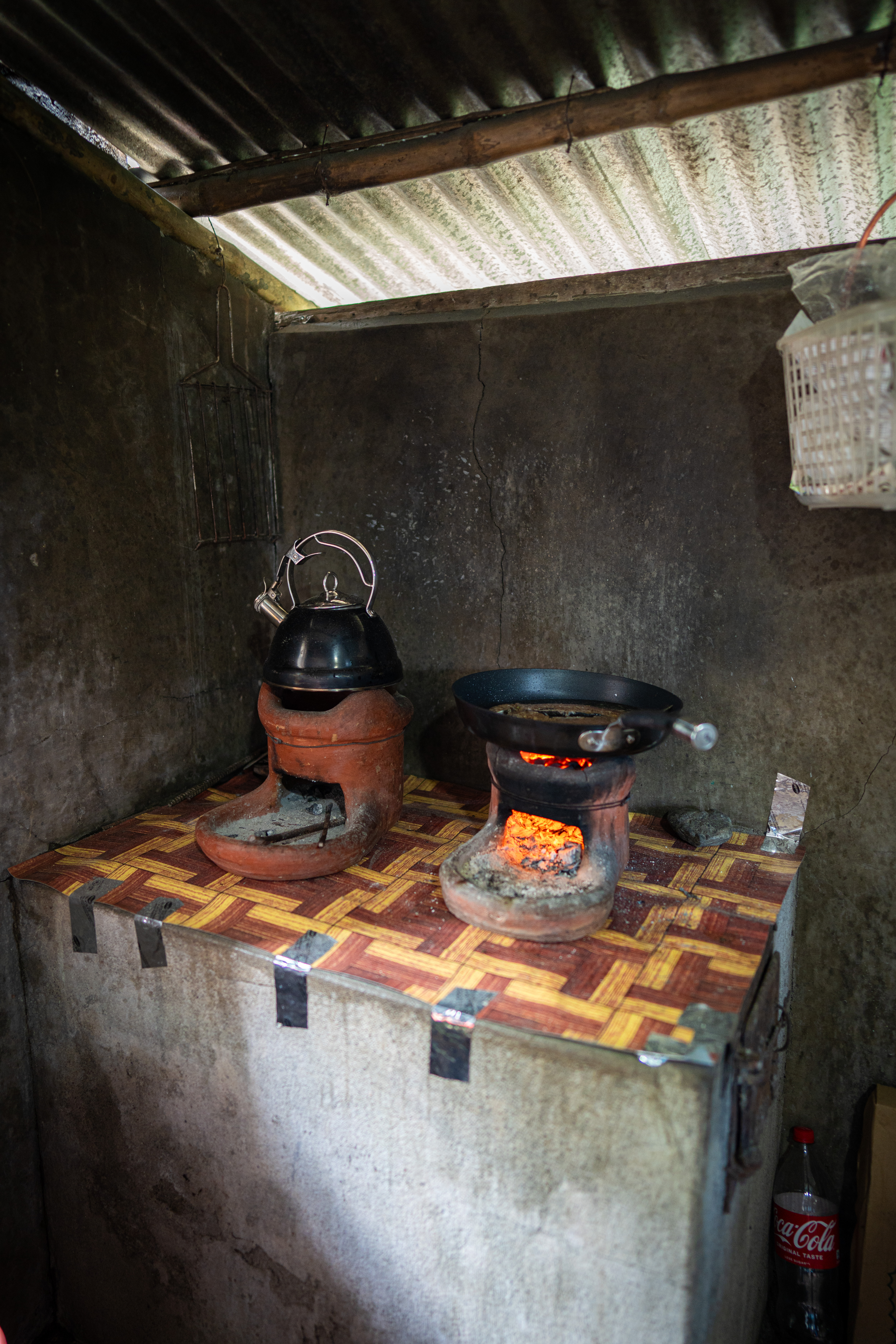 Rustic charcoal-fired clay stove with a kettle and pan