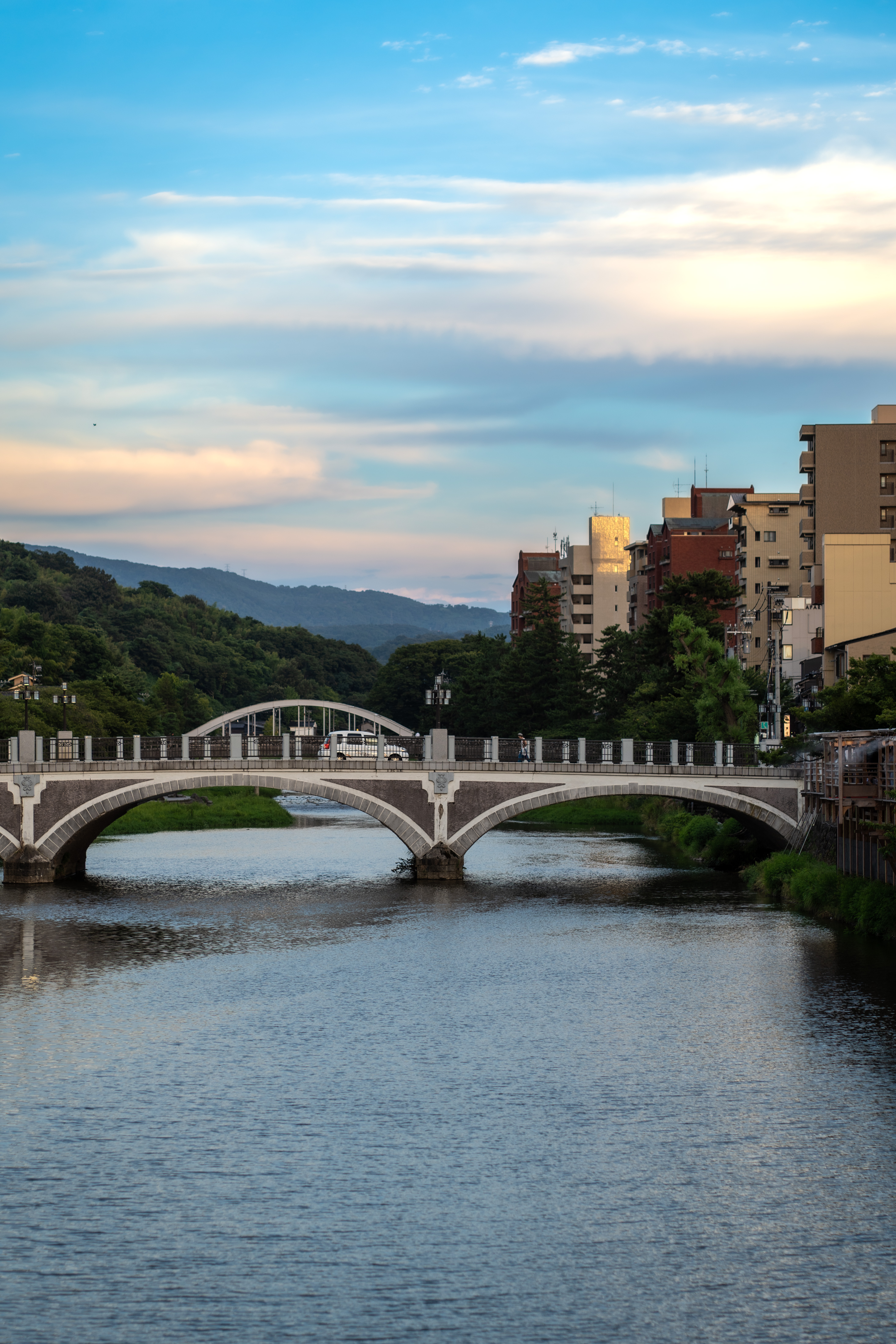 Stone arch bridge over a river in a Japanese mountain town